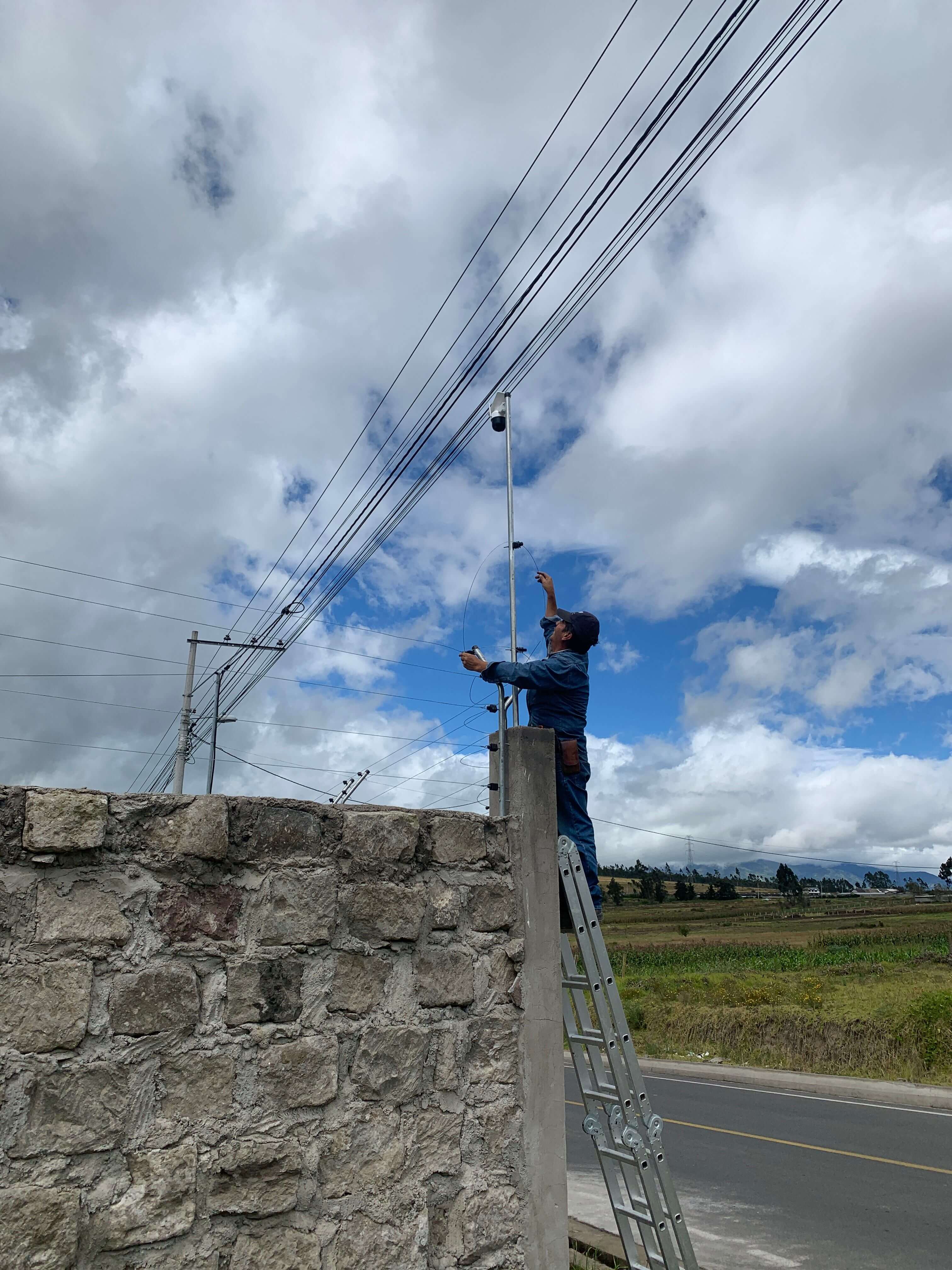 Técnico realizando mantenimiento eléctrico en líneas de cerco eléctrico y cámara de seguridad en Ambato Ecuador